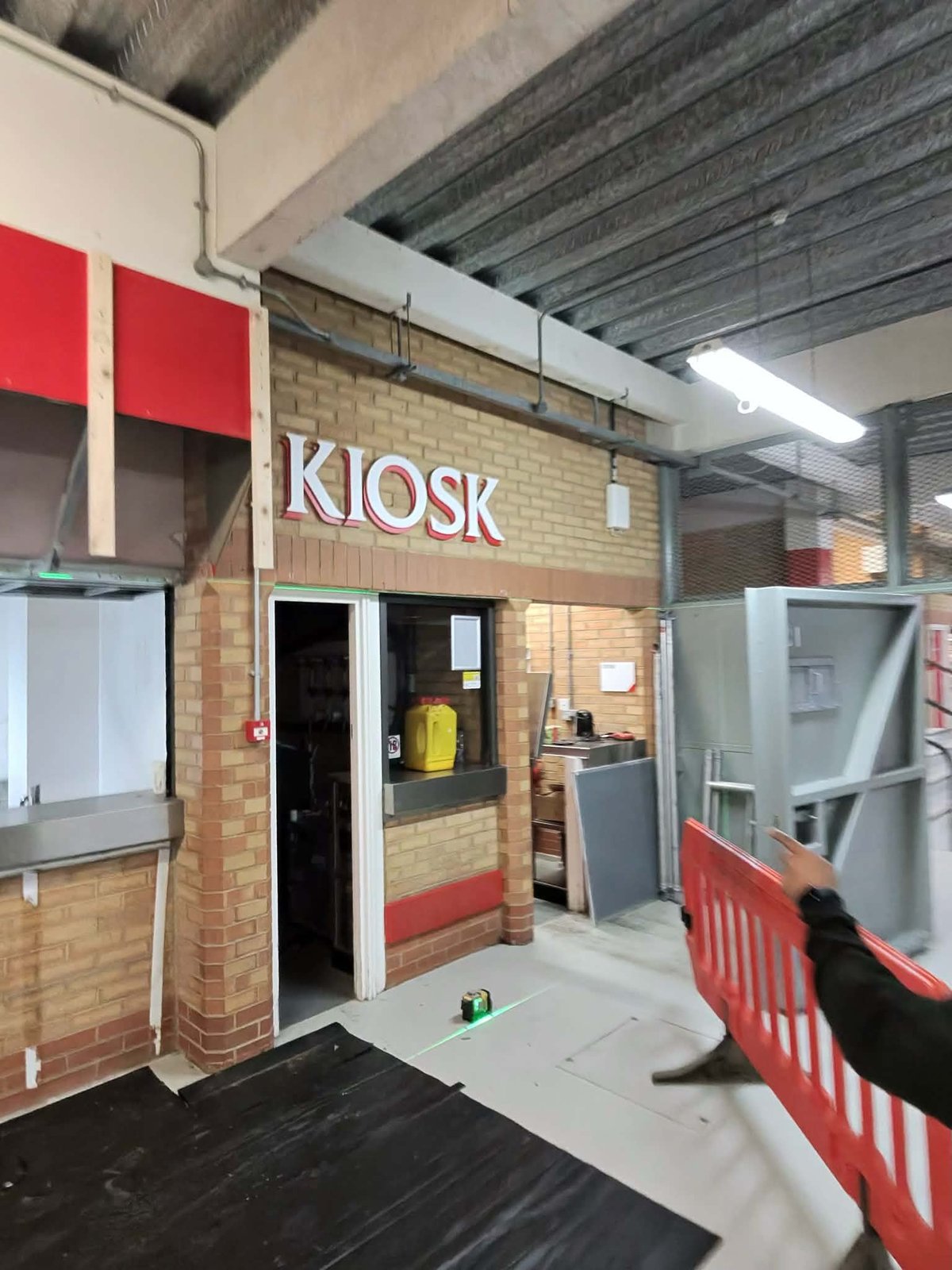 Dempsey Painting & Decorating working on a kiosk inside Anfield