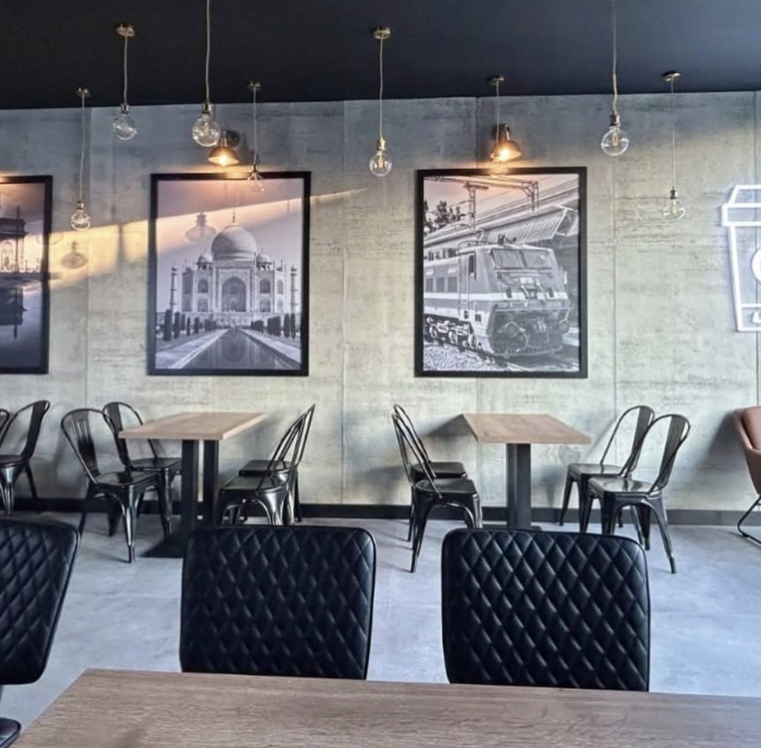 Café seating with framed prints on polished concrete walls
